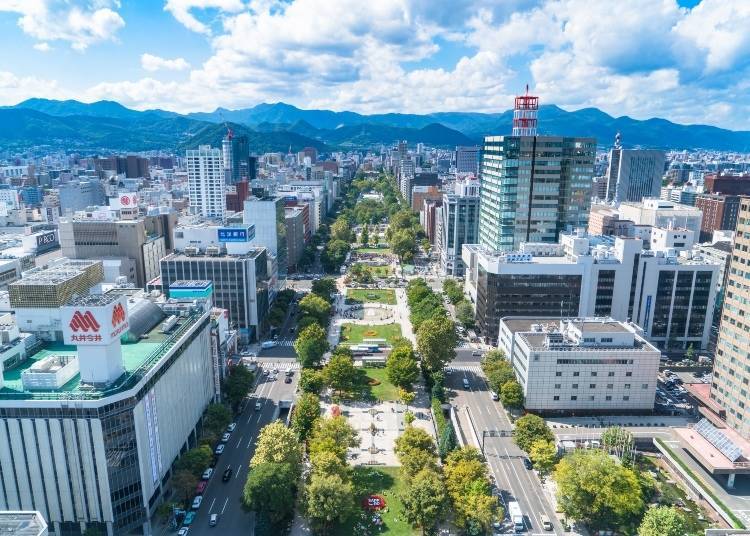 Odori Park and the Sapporo skyline beneath Hokkaido mountains
